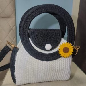 Handcrafted black and white cotton rope mini handbag with round handles, detachable shoulder strap, and decorative sunflower charm for women.