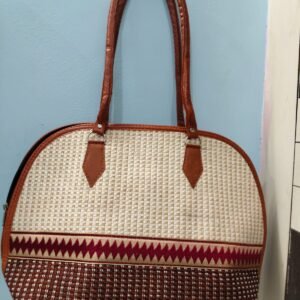 Elegant fabric handbag with ethnic woven pattern and brown faux leather handles for women.