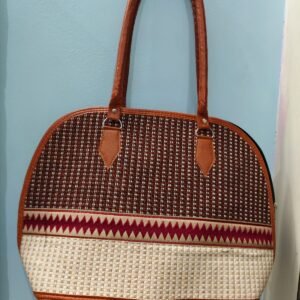 Elegant fabric handbag with ethnic woven pattern and brown faux leather handles for women.